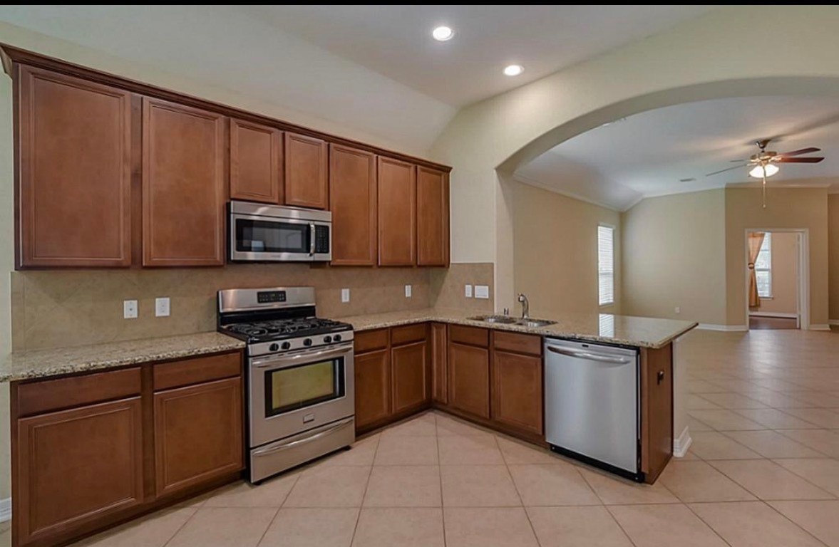 16710 Dover Mills Drive Spring, TX 77379 - Photo 7 of 15 a kitchen with stainless steel appliances granite countertop a stove sink and cabinets