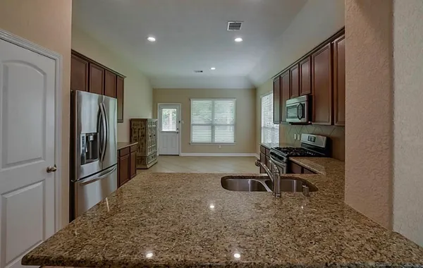 a kitchen with stainless steel appliances granite countertop a refrigerator and a sink