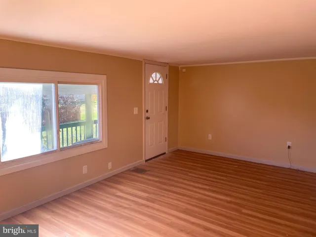 a view of empty room with wooden floor