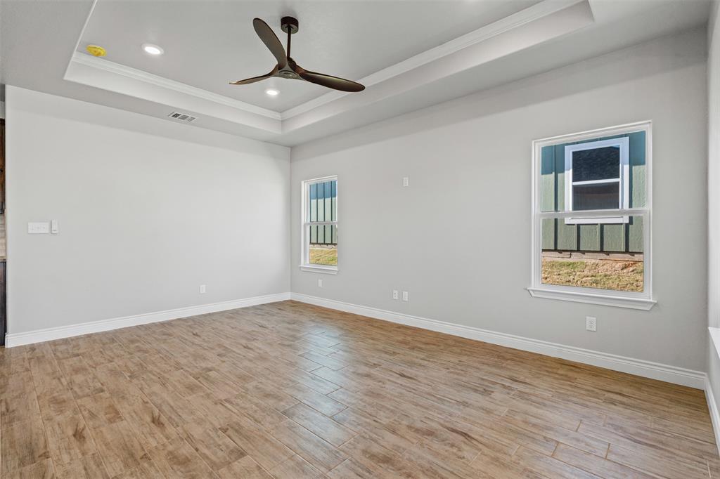 3400 Hilltop Road Granbury, TX 76048 - Photo 12 of 40 a view of an empty room with a window and wooden floor