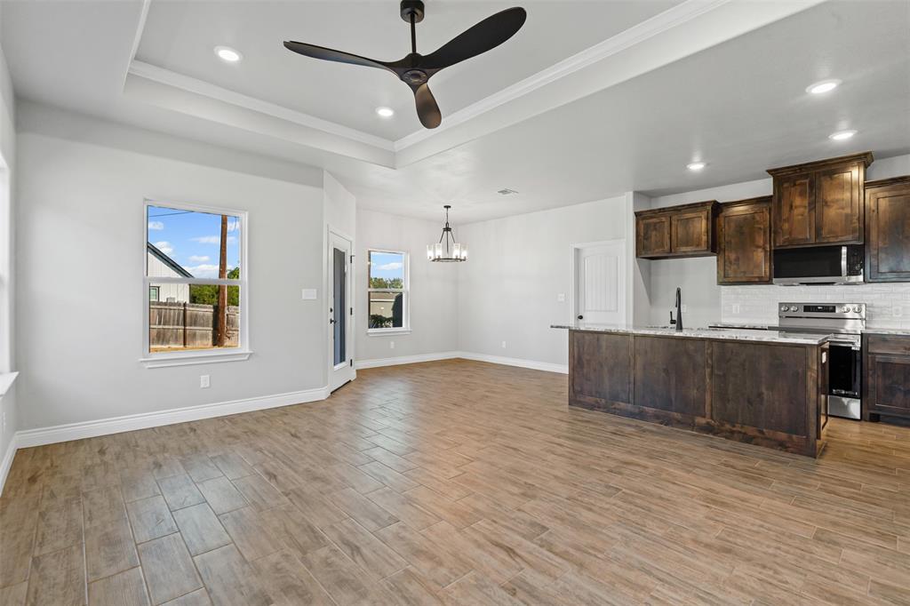 3400 Hilltop Road Granbury, TX 76048 - Photo 13 of 40 a view of kitchen with stainless steel appliances kitchen island wooden floor and living room view