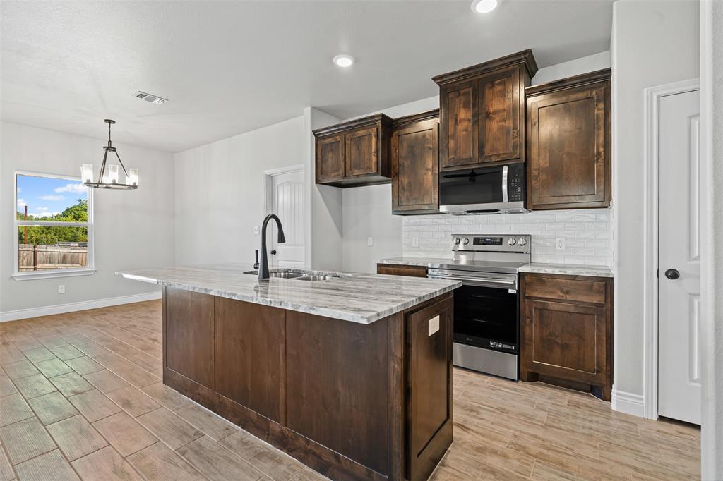 3400 Hilltop Road Granbury, TX 76048 - Photo 16 of 40 a kitchen with stainless steel appliances a sink stove and refrigerator