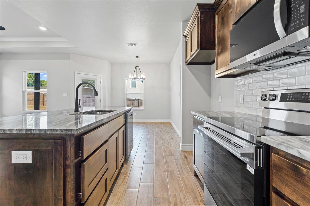 3400 Hilltop Road Granbury, TX 76048 - Photo 22 of 40 a kitchen with granite countertop a sink and a stove top oven