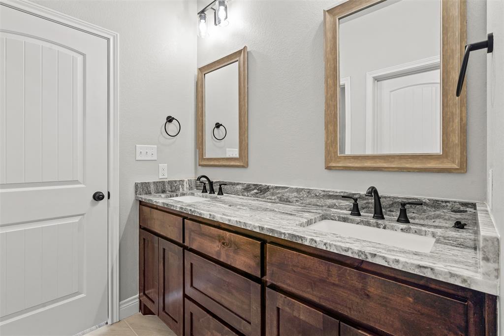 3400 Hilltop Road Granbury, TX 76048 - Photo 25 of 40 a bathroom with a granite countertop sink double and mirror