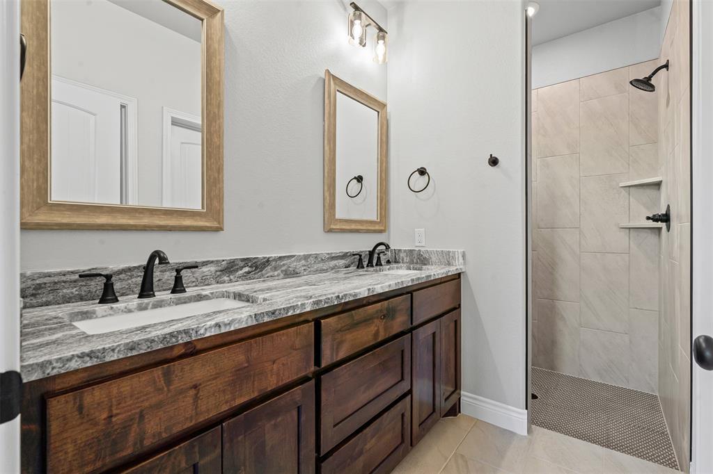3400 Hilltop Road Granbury, TX 76048 - Photo 26 of 40 a bathroom with a granite countertop sink and a mirror