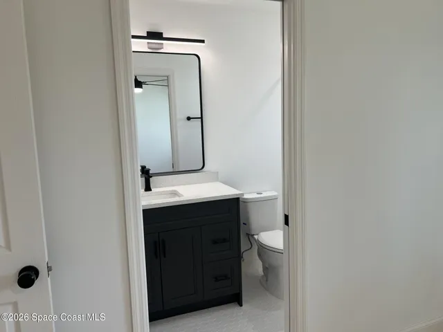 a bathroom with a sink a toilet and mirror