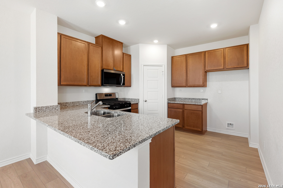 10045 Jagger Avenue Converse, TX 78109 - Photo 13 of 28 a kitchen with a sink stove top oven and microwave