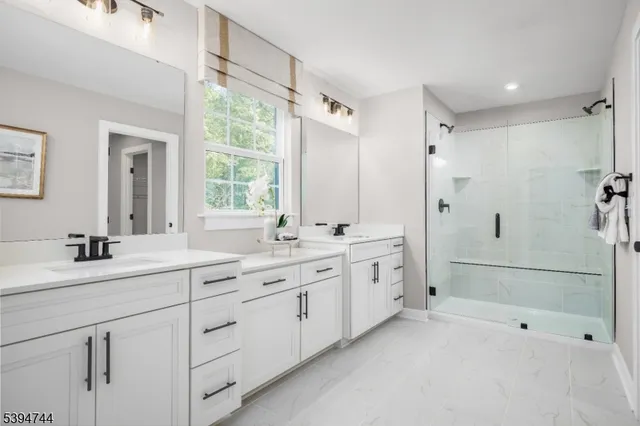 a bathroom with a double vanity sink mirror double and shower