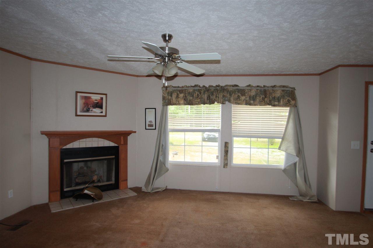 11973 Virgilina Road Roxboro, NC 27574 - Photo 2 of 10 a view of an empty room with a fireplace and a window