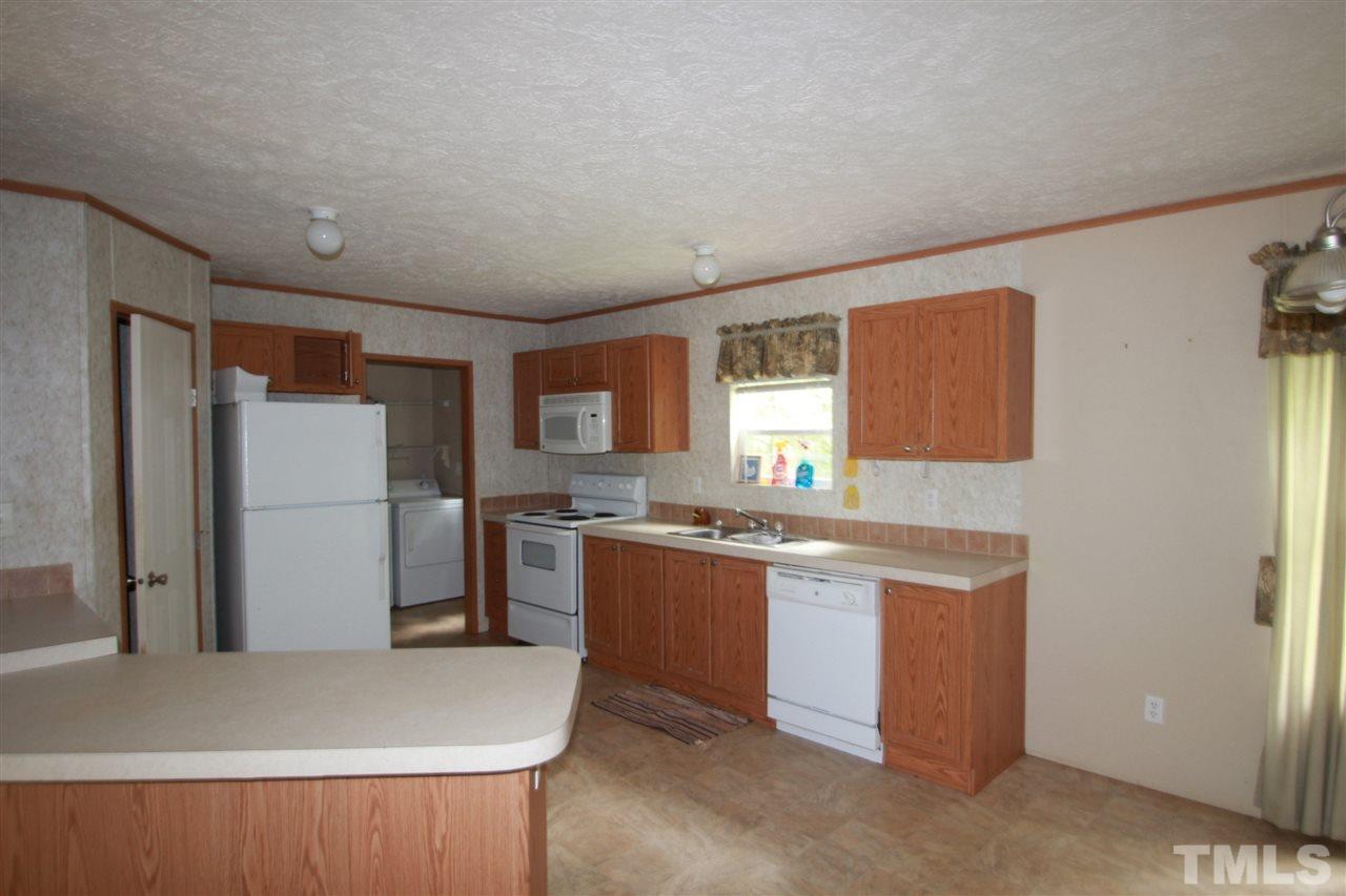 11973 Virgilina Road Roxboro, NC 27574 - Photo 3 of 10 a kitchen with stainless steel appliances granite countertop a refrigerator a sink a stove and a refrigerator