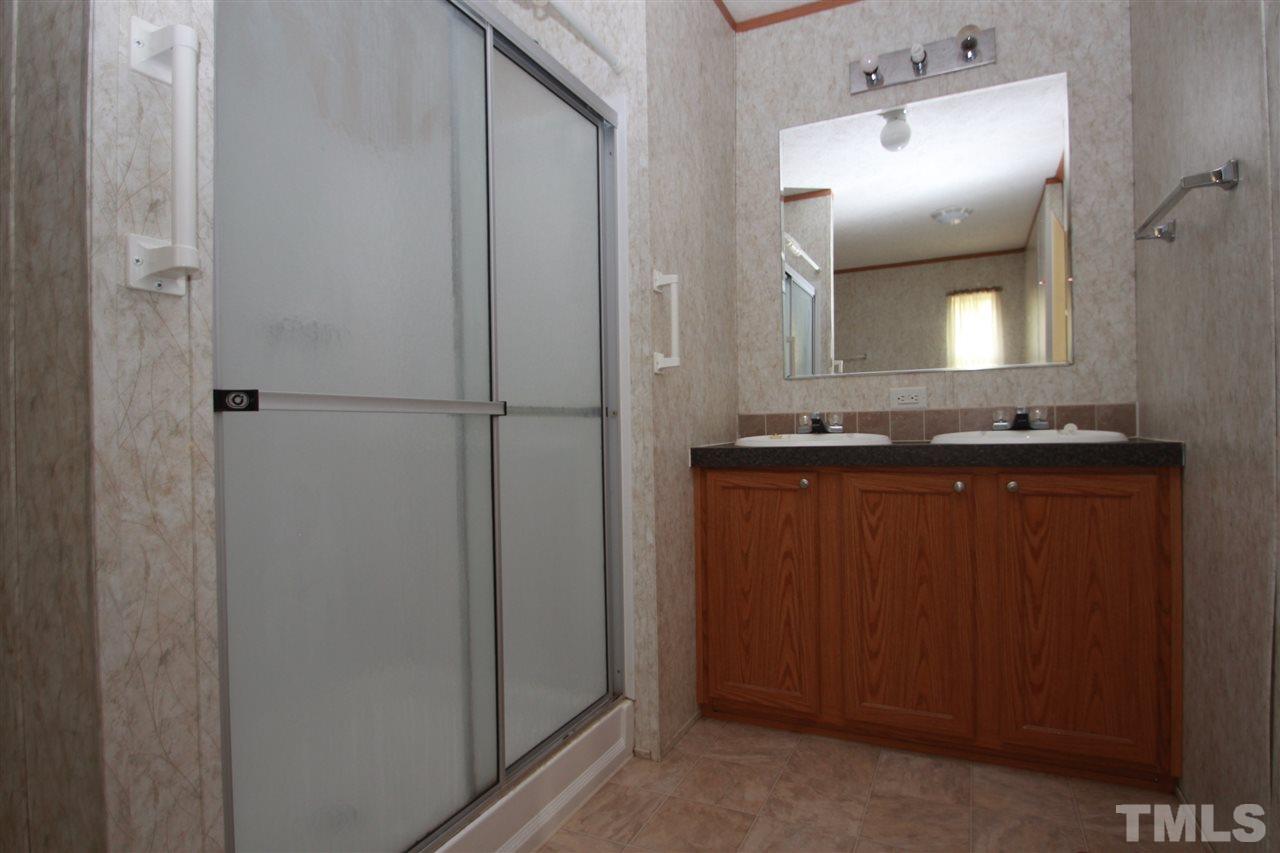 11973 Virgilina Road Roxboro, NC 27574 - Photo 6 of 10 a bathroom with a granite countertop sink and a mirror