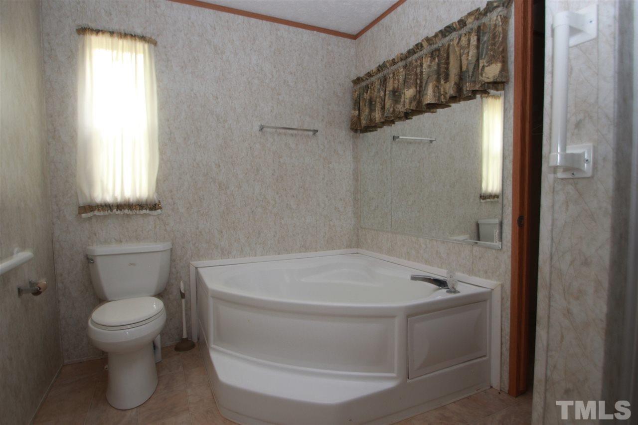 11973 Virgilina Road Roxboro, NC 27574 - Photo 7 of 10 a bathroom with a toilet and a shower