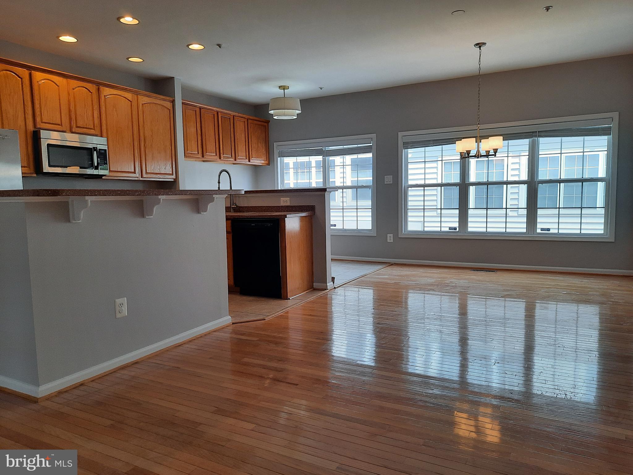 10258 Rutland Round Road, Unit 13 Columbia, MD 21044 - Photo 14 of 46 a kitchen with stainless steel appliances granite countertop a refrigerator a sink dishwasher a stove and a microwave oven on the wooden floor