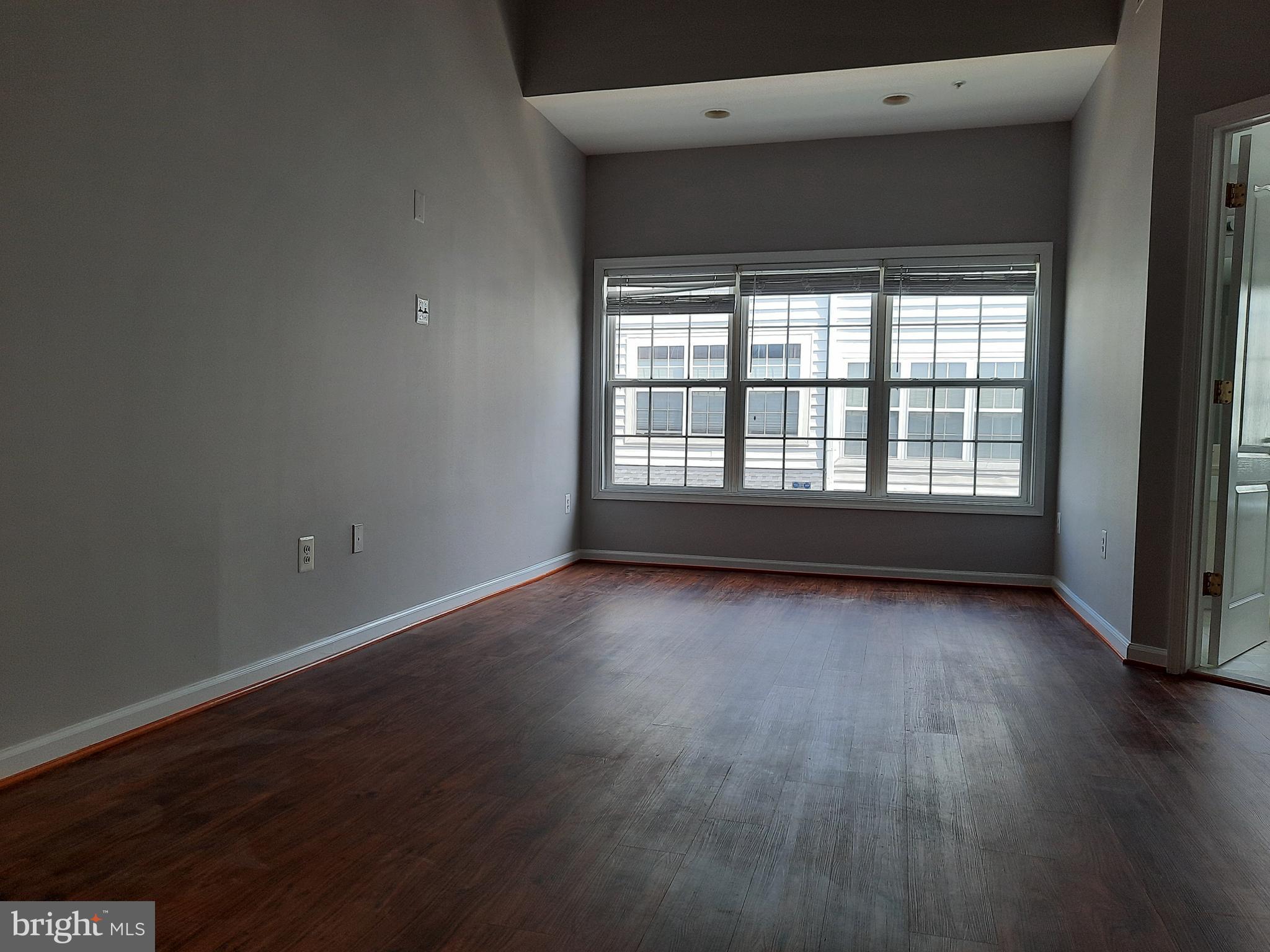 10258 Rutland Round Road, Unit 13 Columbia, MD 21044 - Photo 19 of 46 an empty room with wooden floor and windows