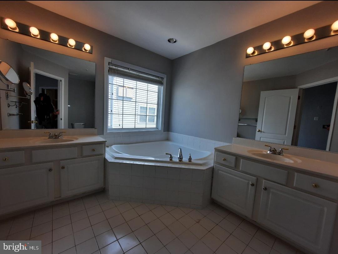 10258 Rutland Round Road, Unit 13 Columbia, MD 21044 - Photo 23 of 46 a bathroom with a tub a sink double vanity and granite