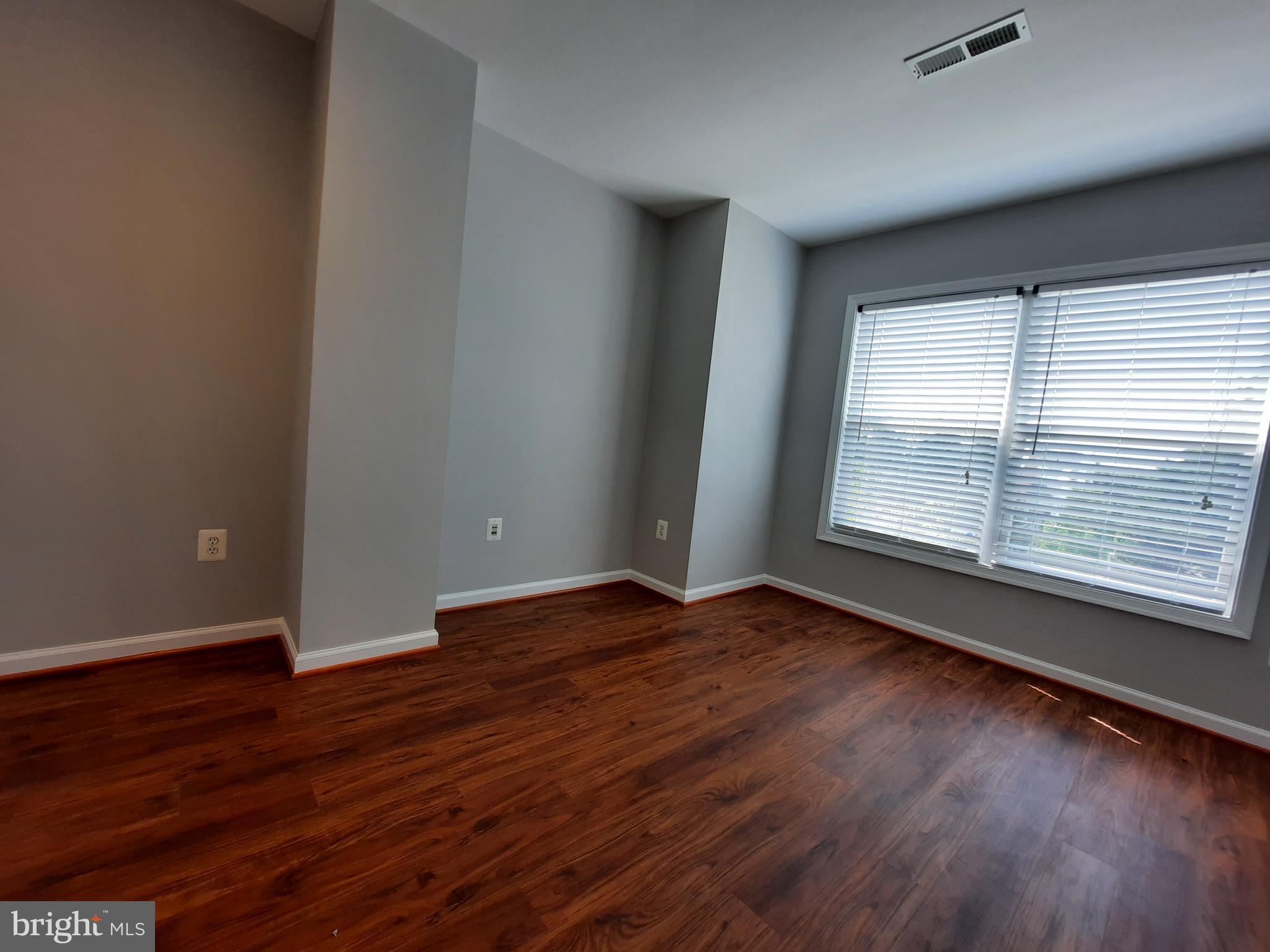 10258 Rutland Round Road, Unit 13 Columbia, MD 21044 - Photo 27 of 46 a view of an empty room with wooden floor and a window