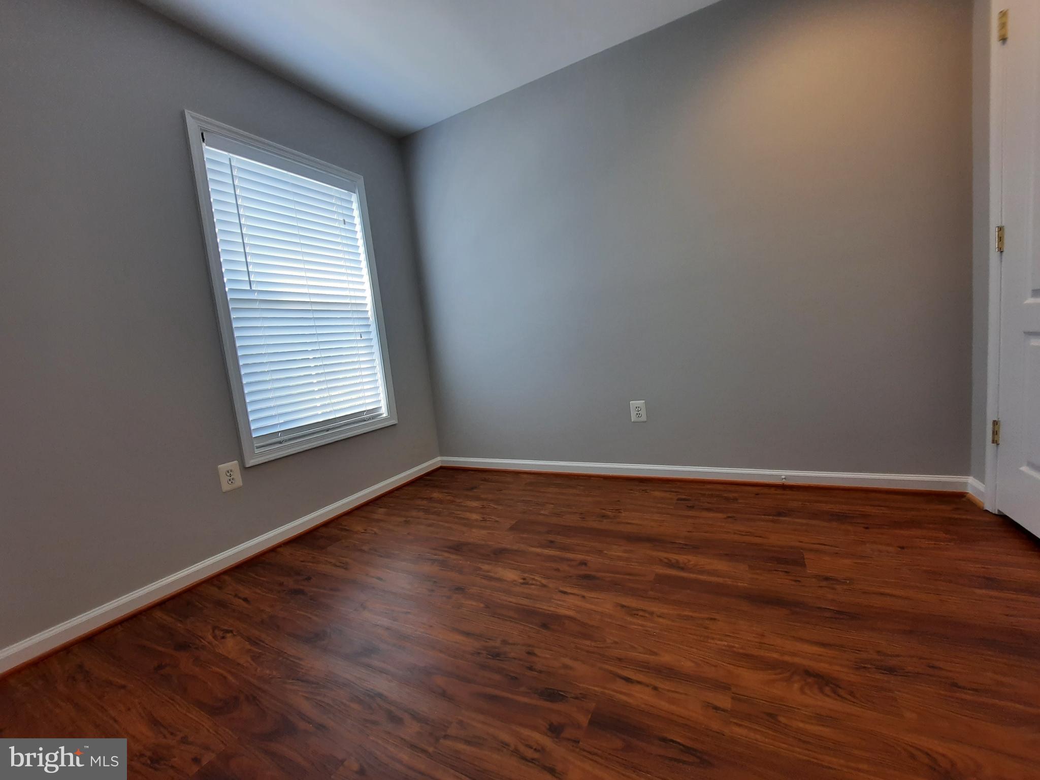 10258 Rutland Round Road, Unit 13 Columbia, MD 21044 - Photo 28 of 46 a view of an empty room with wooden floor and a window