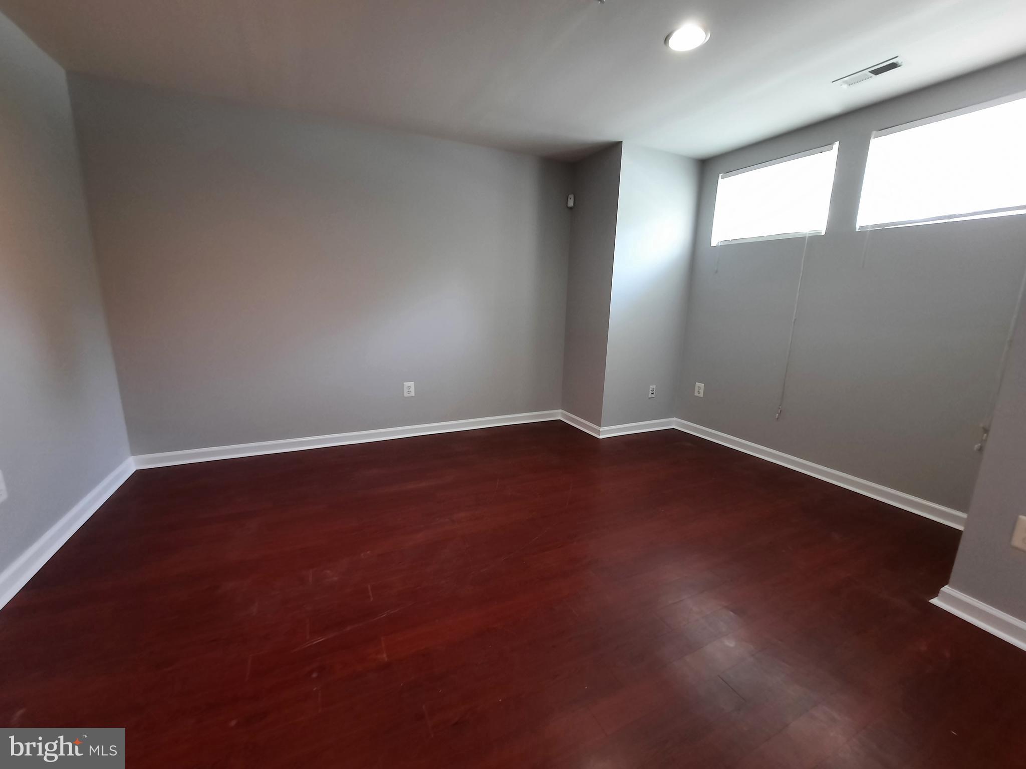 10258 Rutland Round Road, Unit 13 Columbia, MD 21044 - Photo 35 of 46 an empty room with wooden floor and windows