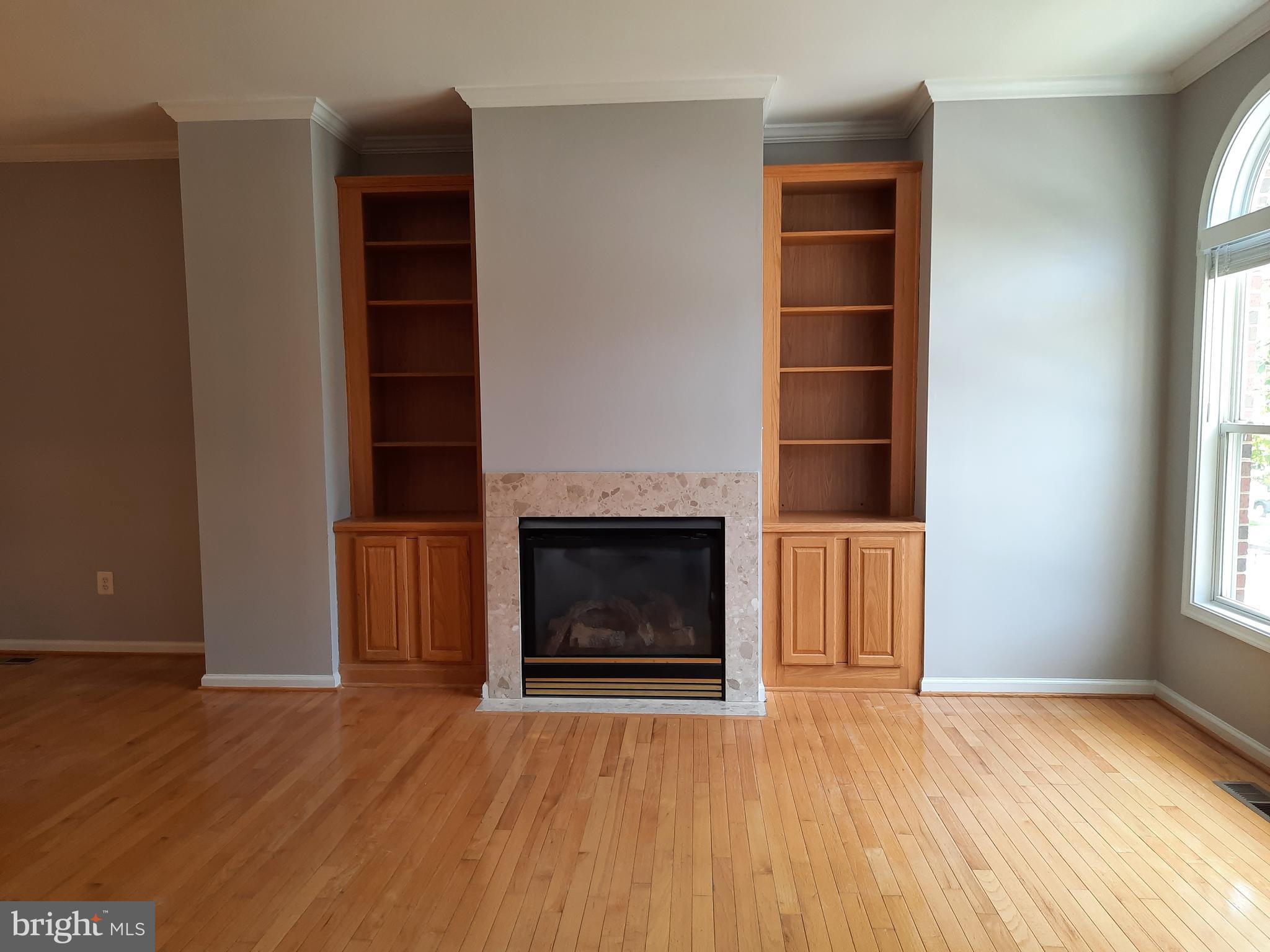 10258 Rutland Round Road, Unit 13 Columbia, MD 21044 - Photo 4 of 46 an empty room with wooden floor fireplace and windows
