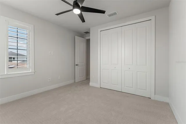an empty room with a window and a fan