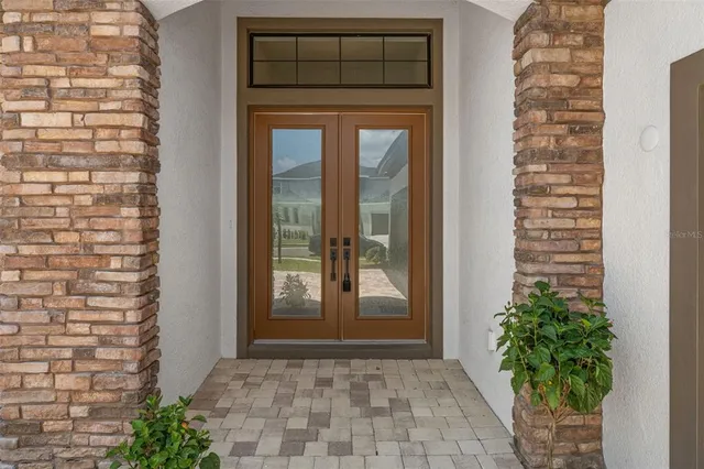 a view of a bathroom from the hallway with a glass door and a bathroom