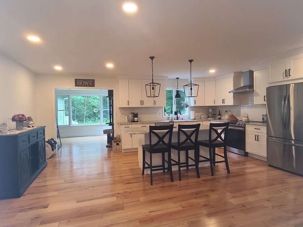 123 Boston Road Palmer, MA 01069 - Photo 5 of 33 a kitchen with stainless steel appliances a dining table chairs refrigerator and cabinets