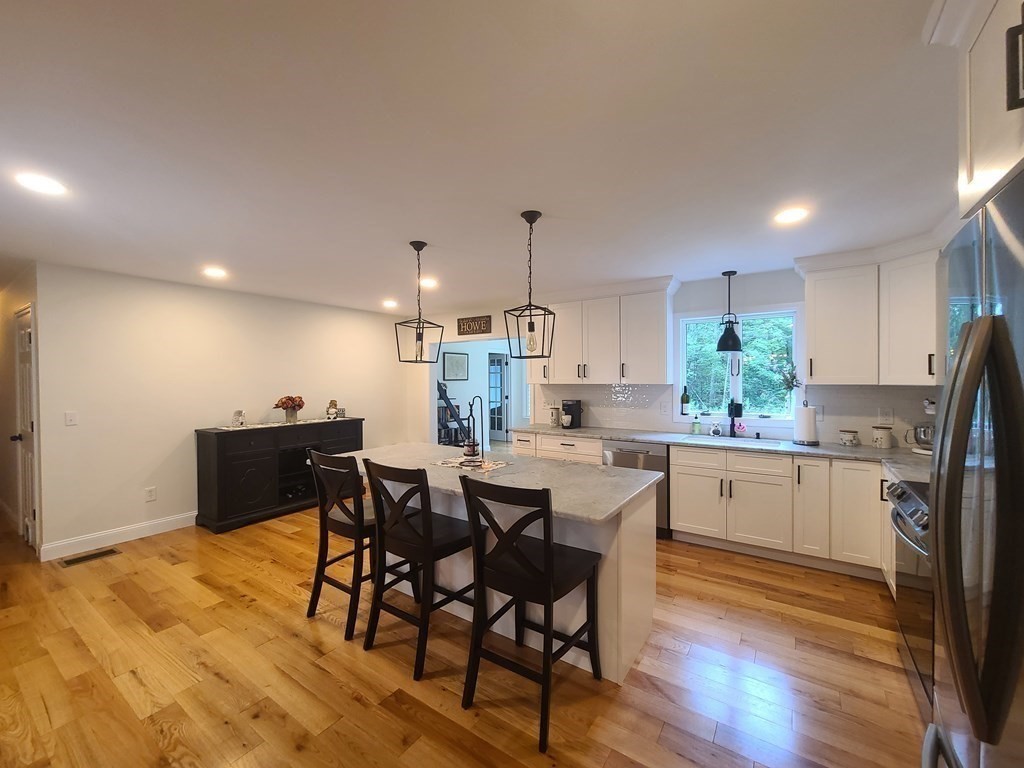 123 Boston Road Palmer, MA 01069 - Photo 8 of 33 a kitchen with stainless steel appliances a dining table chairs and wooden floor