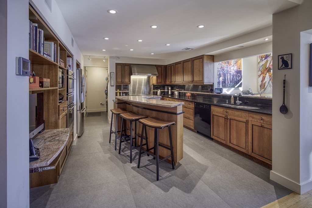 37 Beverly Road Arlington, MA 02474 - Photo 12 of 42 a kitchen with stainless steel appliances kitchen island granite countertop a table and chairs in it