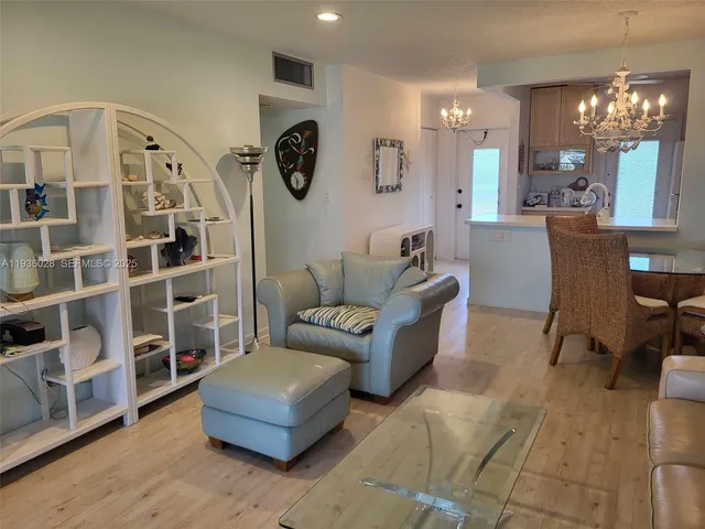 a living room with furniture and a large mirror with wooden floor