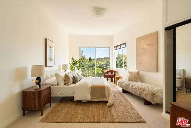 a bedroom with furniture and a large window