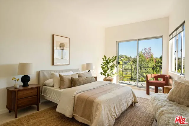 a bedroom with a bed and a large window