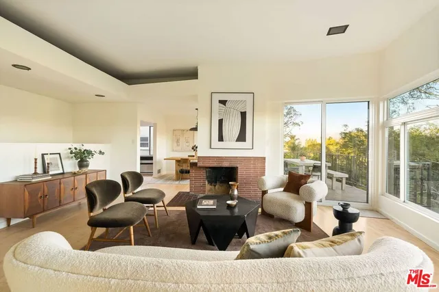a living room with furniture fireplace and large windows