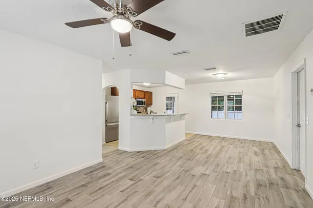 a view of a room with wooden floor and a ceiling fan
