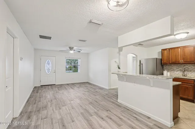 a view of a kitchen with wooden floor and electronic appliances