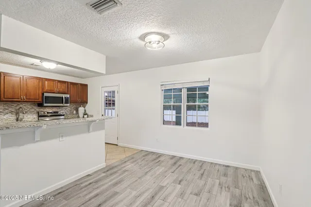 a view of a kitchen with microwave and cabinets