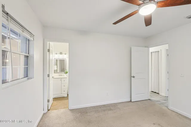 a view of an empty room with window and cabinet