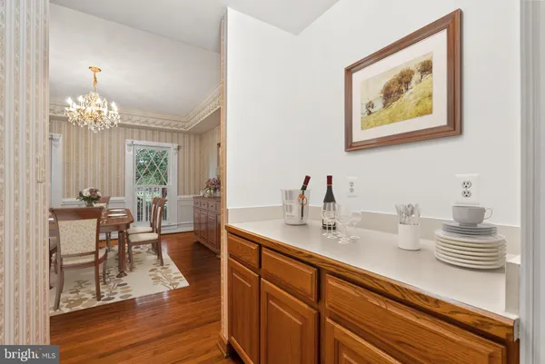a dining room with wooden floor a chandelier a wooden table and chairs