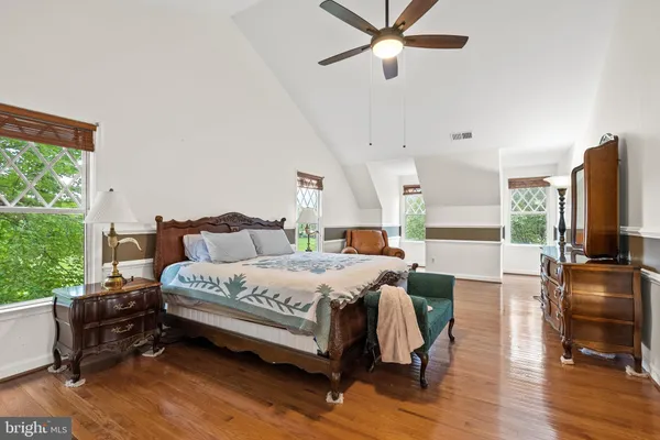 a spacious bedroom with a bed a couch and dresser in it