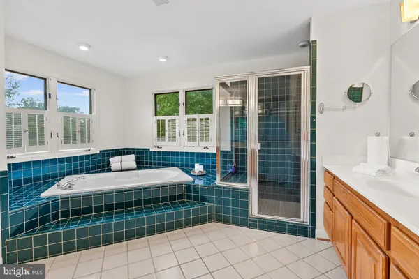 a large bathroom with a sink mirror and cabinets