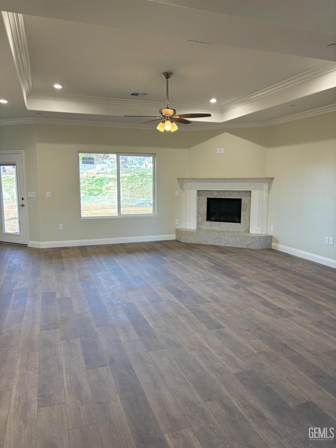 Undisclosed Address Tehachapi, CA 93561 - Photo 11 of 15 an empty room with wooden floor fireplace and windows