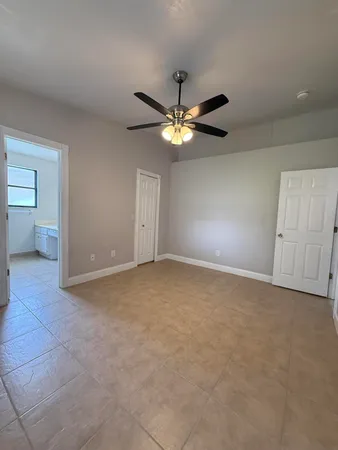 a view of an empty room and a ceiling fan