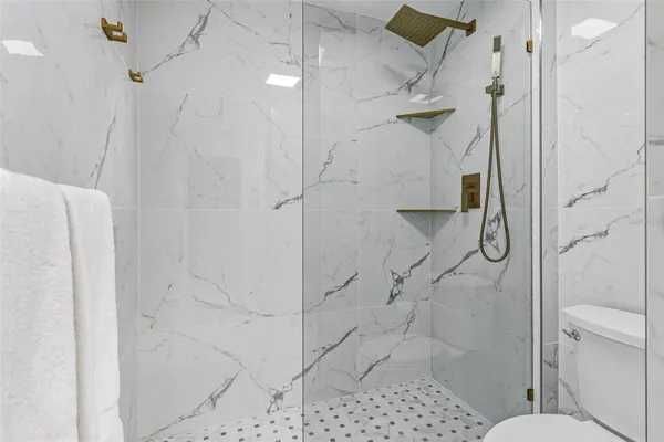 a bathroom with a toilet and a shower