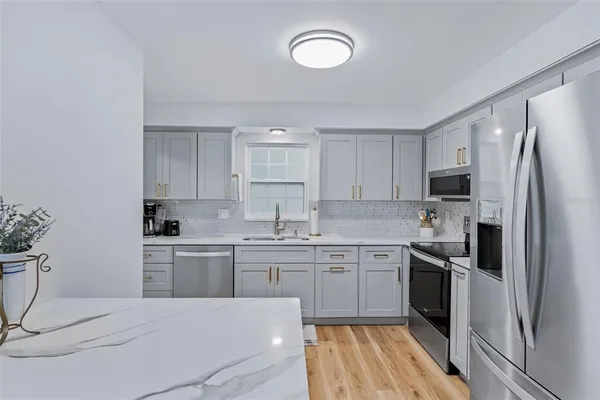 a living room with furniture and a dining table with wooden floor