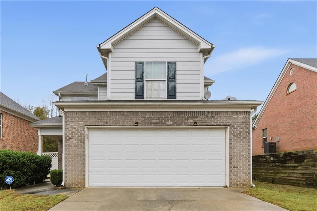 a view of a house with garage and plants