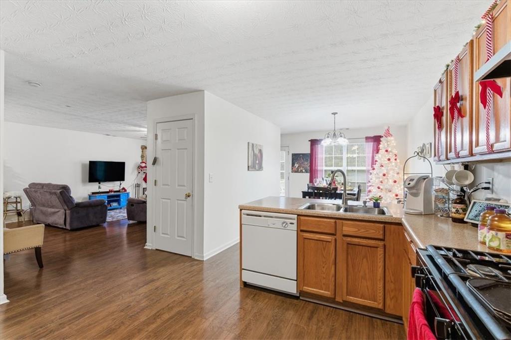 809 Winsap Drive Stockbridge, GA 30281 - Photo 15 of 41 a kitchen with stainless steel appliances a stove top oven a sink a dining table and chairs with wooden floor