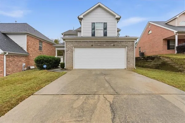 a front view of a house with a yard and garage