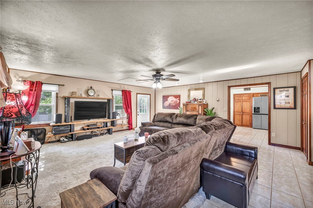 8164 Edgewood Road Mentor, OH 44060 - Photo 8 of 42 Carpeted living room with wood walls, a textured ceiling, and ceiling fan