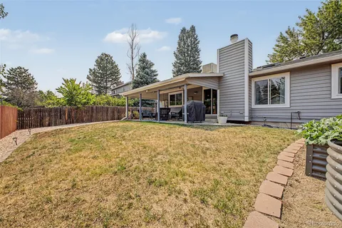 a view of a house with a backyard and trees