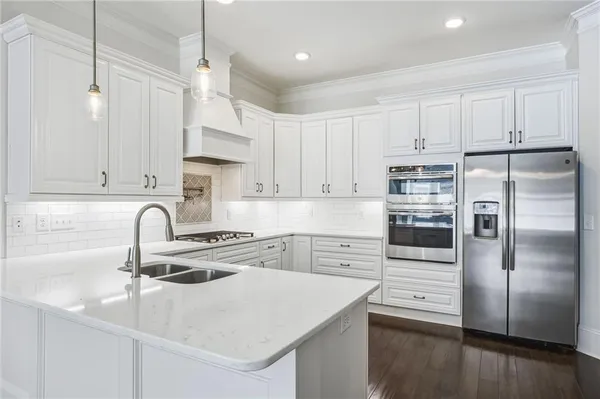 a kitchen with a sink stainless steel appliances and white cabinets