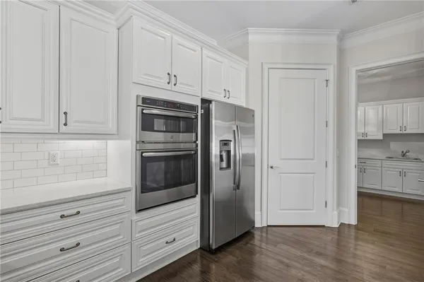 a kitchen with white cabinets and stainless steel appliances